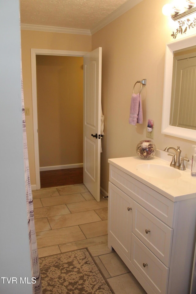 bathroom with vanity, ornamental molding, and a textured ceiling
