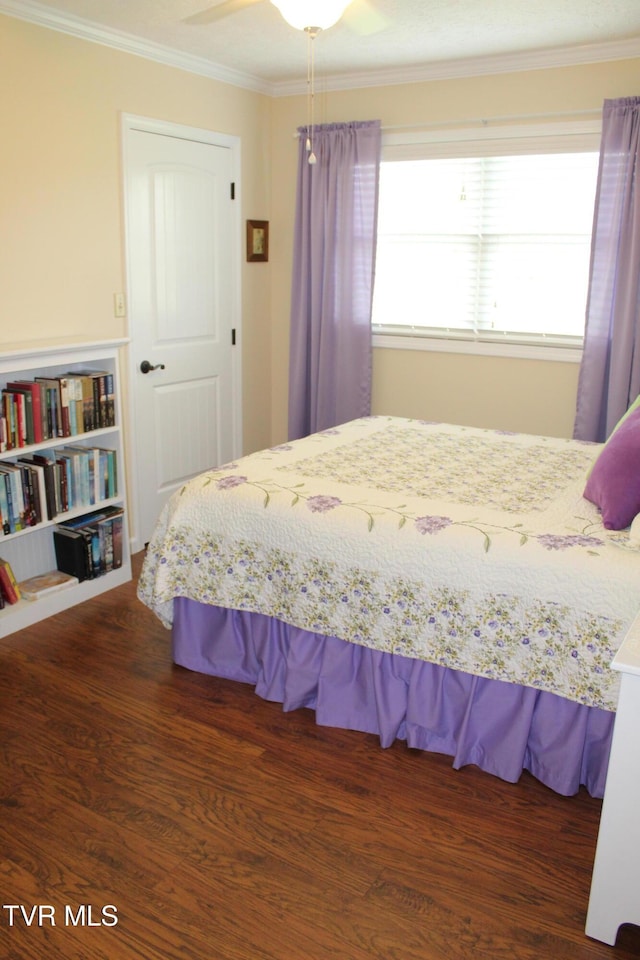 bedroom with wood finished floors and crown molding