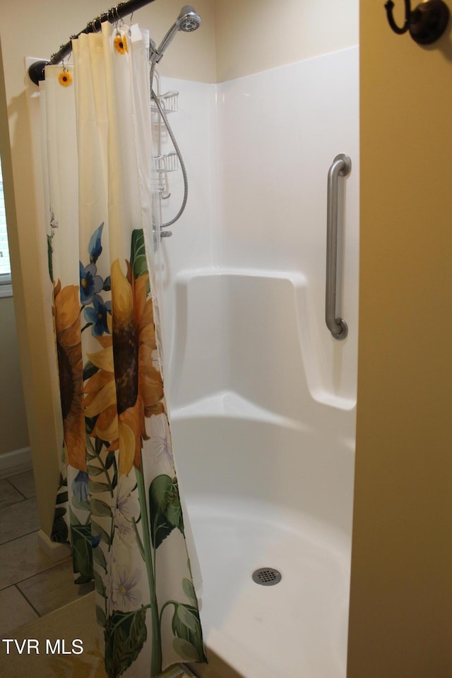 full bathroom with a shower with curtain and tile patterned flooring