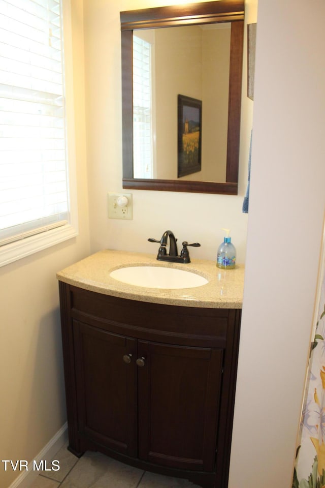 bathroom with healthy amount of natural light, vanity, and tile patterned floors