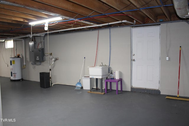 unfinished below grade area featuring electric water heater, concrete block wall, electric panel, and a sink