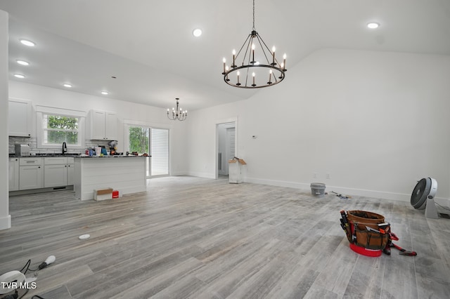 173 Paynetown Rd, Telford, TN 37690 - unfurnished living room with an inviting chandelier, vaulted ceiling, light wood-style flooring, and a sink