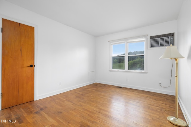 216 Sunbury Ct, Kingsport, TN 37664 - empty room featuring wood finished floors, baseboards, and a wall unit AC