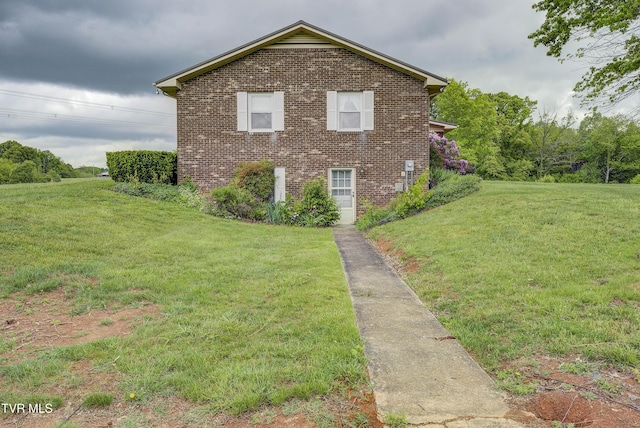 view of property exterior with brick siding and a yard