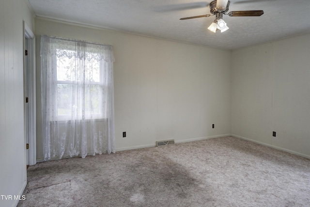 unfurnished room with carpet flooring, a ceiling fan, a textured ceiling, and baseboards