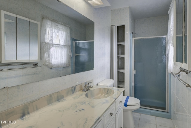 bathroom featuring tile walls, a shower stall, tile patterned flooring, toilet, and vanity