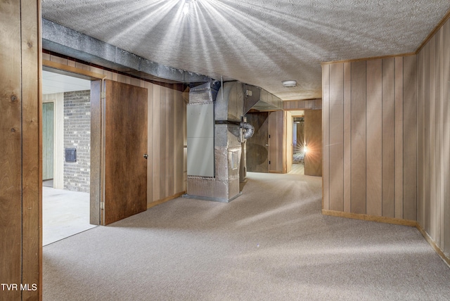 hallway featuring carpet flooring, wood walls, a textured ceiling, and heating unit