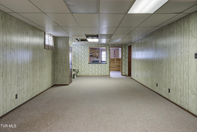 basement featuring a drop ceiling, carpet, and wallpapered walls