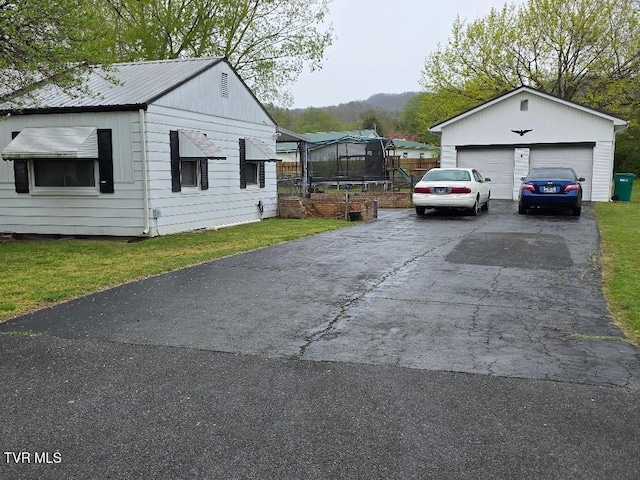 214 Elliott, Erwin, TN 37650 - view of side of property featuring a detached garage, a yard, and a trampoline