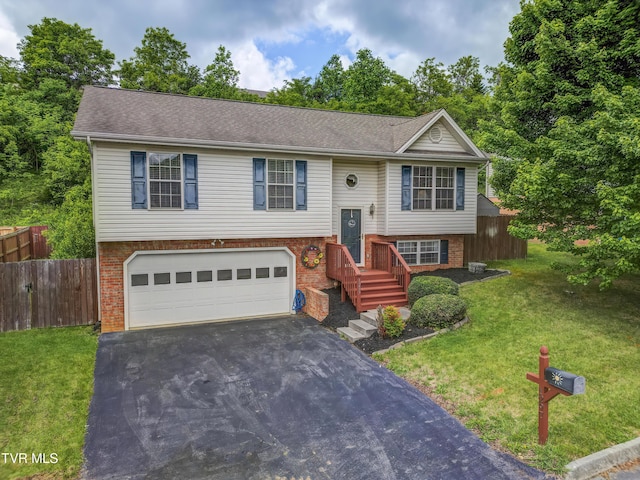 split foyer home featuring asphalt driveway, a garage, brick siding, and roof with shingles