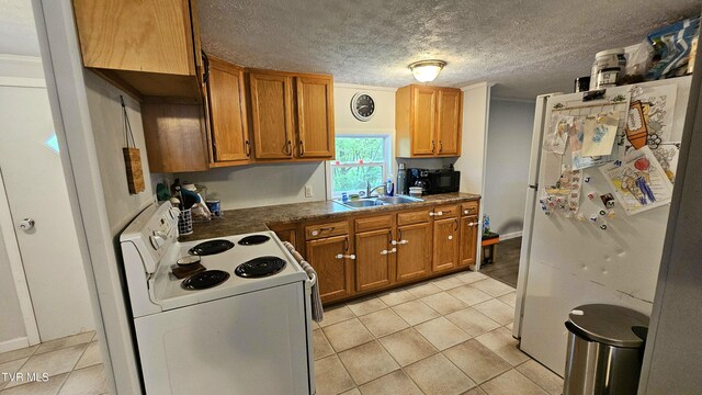 824 W Buckner Ave, Big Stone Gap, VA 24219 - kitchen with white appliances, a sink, light tile patterned flooring, brown cabinets, and a textured ceiling