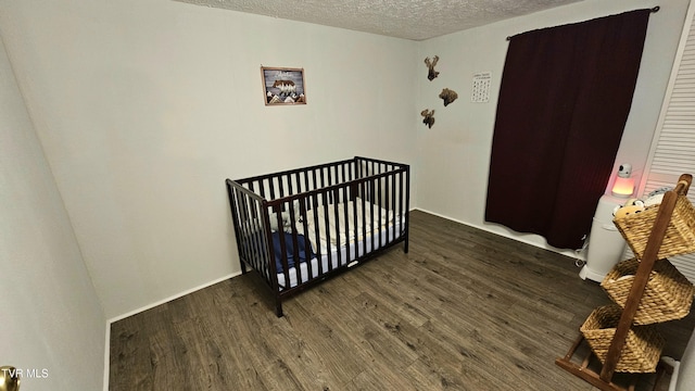 824 W Buckner Ave, Big Stone Gap, VA 24219 - bedroom with a textured ceiling, wood finished floors, and a nursery area