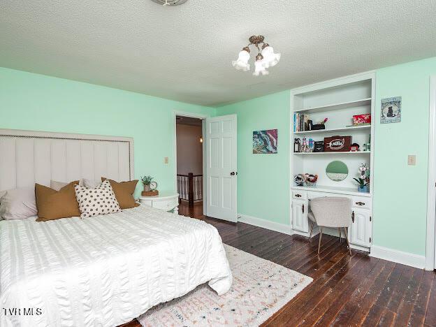 26354 Pewter Ln, Abingdon, VA 24211 - bedroom featuring dark wood finished floors, an office area, baseboards, and a chandelier