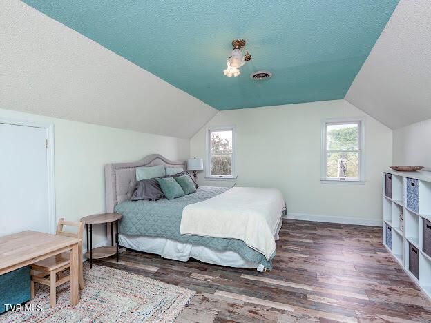 26354 Pewter Ln, Abingdon, VA 24211 - bedroom with wood finished floors, vaulted ceiling, a textured ceiling, and baseboards