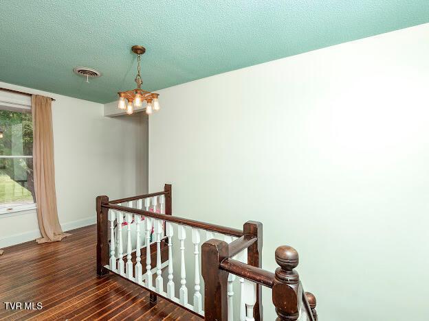 26354 Pewter Ln, Abingdon, VA 24211 - corridor featuring an upstairs landing, wood finished floors, a chandelier, baseboards, and a textured ceiling