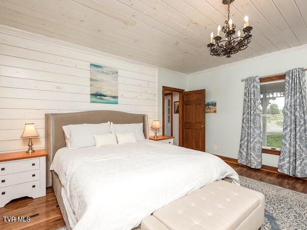 26354 Pewter Ln, Abingdon, VA 24211 - bedroom featuring a chandelier, wood finished floors, wooden ceiling, ornamental molding, and wood walls