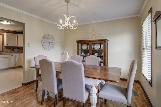 719 W Valley Dr, Kingsport, TN 37664 - dining area with a chandelier, light wood-style flooring, crown molding, and baseboards