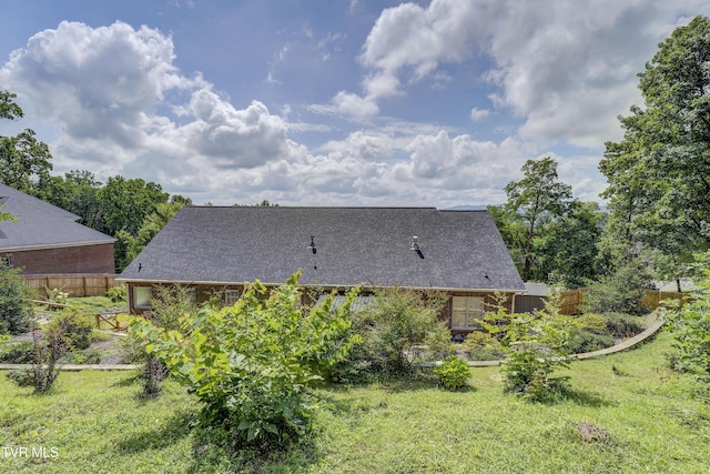 back of house featuring a shingled roof