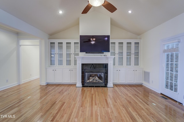 unfurnished living room featuring lofted ceiling, a tiled fireplace, light wood-style flooring, ceiling fan, and recessed lighting
