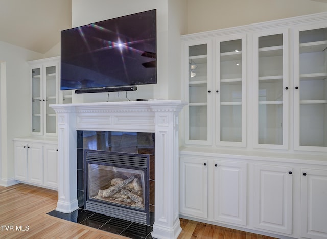 detailed view of wood finished floors and a tile fireplace