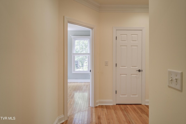 hallway with crown molding and light wood finished floors