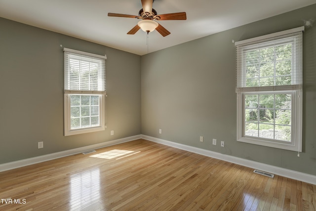 unfurnished room with healthy amount of natural light, light wood finished floors, and a ceiling fan