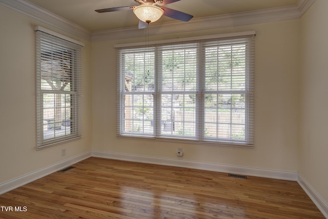 empty room featuring crown molding, wood finished floors, and ceiling fan