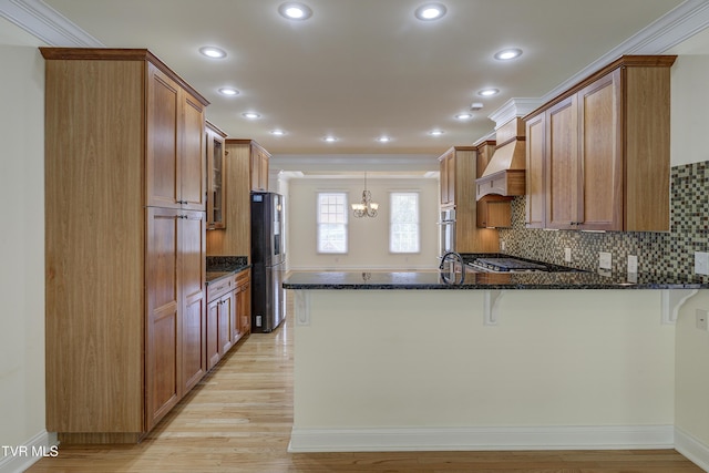 kitchen with a peninsula, dark stone counters, a chandelier, a breakfast bar, and recessed lighting