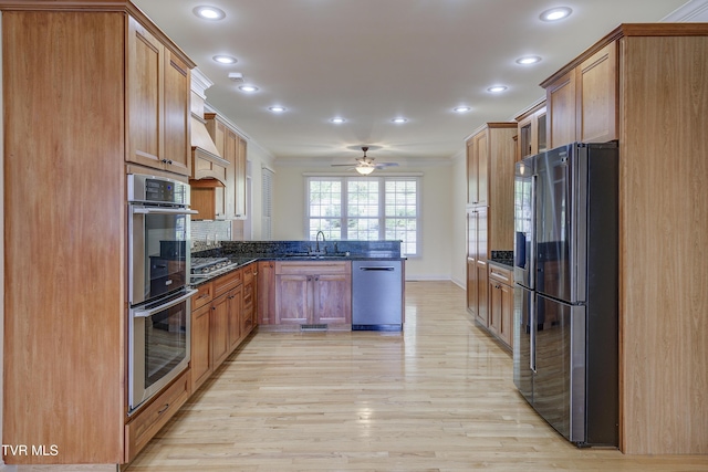 kitchen featuring a peninsula, stainless steel appliances, recessed lighting, light wood-style flooring, and ornamental molding