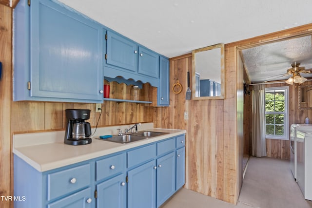590 Kingsport Hwy, Greeneville, TN 37745 - kitchen featuring washer and dryer, blue cabinetry, wooden walls, a sink, and a ceiling fan