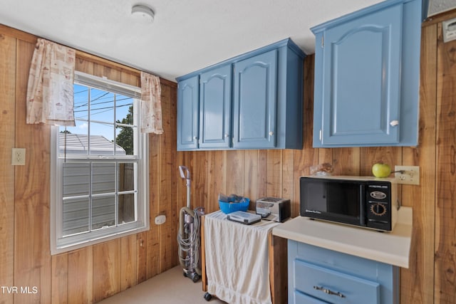 590 Kingsport Hwy, Greeneville, TN 37745 - kitchen featuring blue cabinetry, black microwave, wood walls, and light countertops
