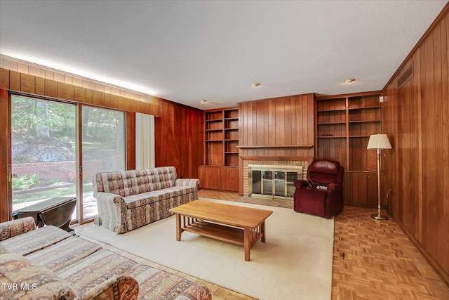 4401 Beechcliff Dr, Kingsport, TN 37664 - living room with wood walls, built in shelves, a fireplace with flush hearth, and a textured ceiling