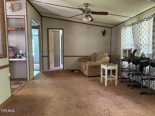carpeted living area with a ceiling fan