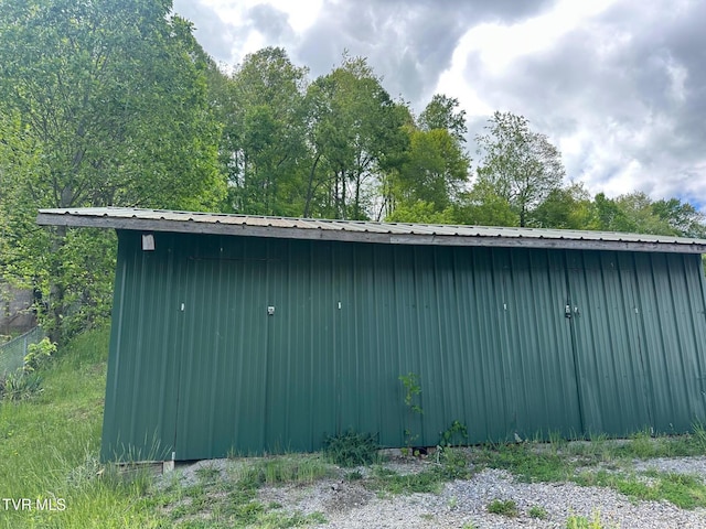 view of home's exterior with an outbuilding, metal roof, and a storage unit