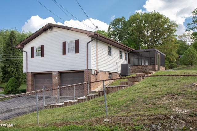 7324 White Pine Cir, Bristol, VA 24202 - view of property exterior featuring brick siding, asphalt driveway, a garage, a sunroom, and central air condition unit