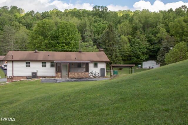 7324 White Pine Cir, Bristol, VA 24202 - back of property featuring a yard, central AC, a chimney, and a view of trees