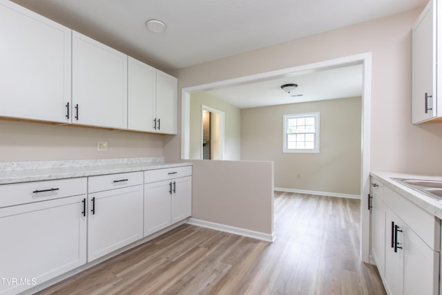 7324 White Pine Cir, Bristol, VA 24202 - kitchen with light wood-style floors, light countertops, white cabinetry, and baseboards