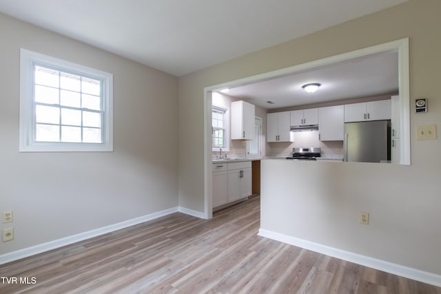 7324 White Pine Cir, Bristol, VA 24202 - kitchen with appliances with stainless steel finishes, under cabinet range hood, a sink, white cabinets, and light countertops
