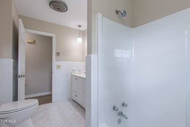 7324 White Pine Cir, Bristol, VA 24202 - bathroom featuring toilet, marble look tiles, a wainscoted wall, shower / tub combination, and tile walls