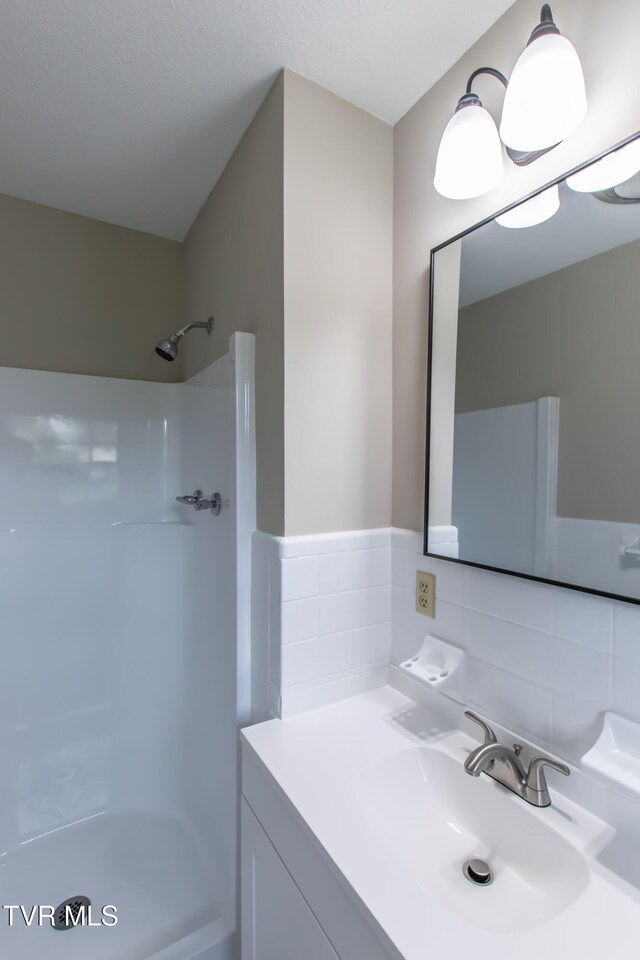 7324 White Pine Cir, Bristol, VA 24202 - bathroom featuring tile walls, a shower, and vanity