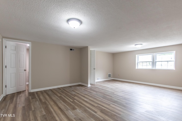 7324 White Pine Cir, Bristol, VA 24202 - below grade area featuring a textured ceiling, wood finished floors, and baseboards
