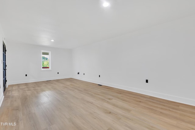 spare room with baseboards, light wood-style floors, and recessed lighting