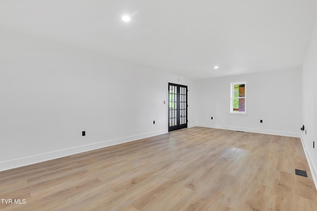 spare room featuring light wood-style floors, recessed lighting, and baseboards