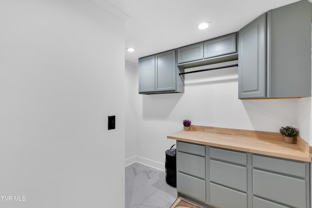 laundry area with light marble finish flooring, recessed lighting, and baseboards