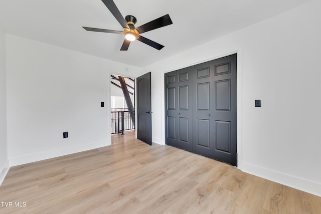 unfurnished bedroom with baseboards, light wood finished floors, a closet, and a ceiling fan