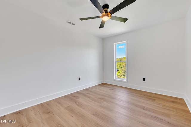 spare room featuring baseboards, light wood-type flooring, and ceiling fan