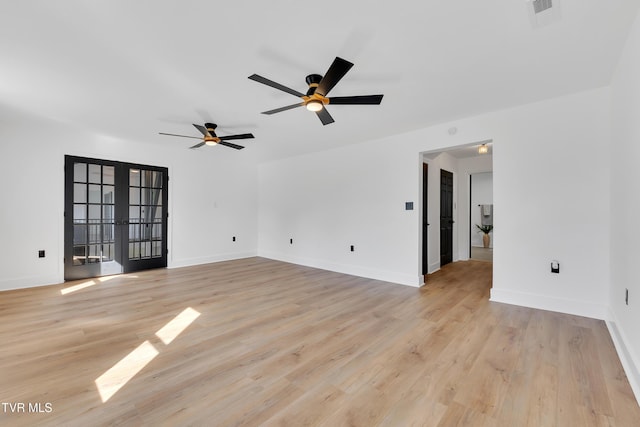 spare room featuring french doors, a ceiling fan, light wood finished floors, and baseboards