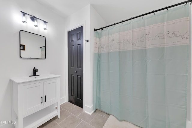 full bathroom with tile patterned floors, vanity, baseboards, and curtained shower