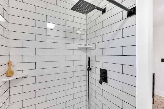 full bath with a tile shower and baseboards