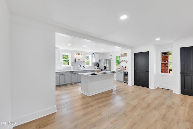 kitchen featuring open shelves, stainless steel fridge, wine cooler, light countertops, and recessed lighting